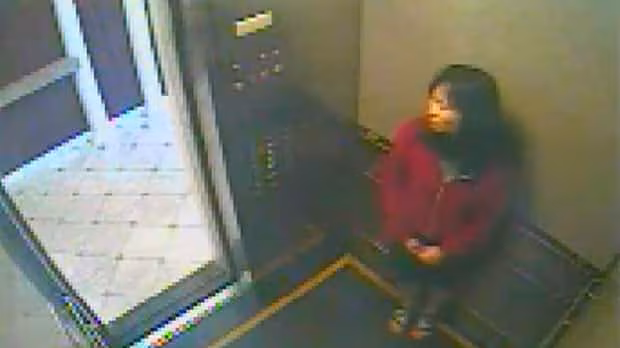 Elisa Lam realizando gestos extraños con las manos fuera del ascensor del Hotel Cecil en el video de seguridad CCTV, posible evidencia paranormal.