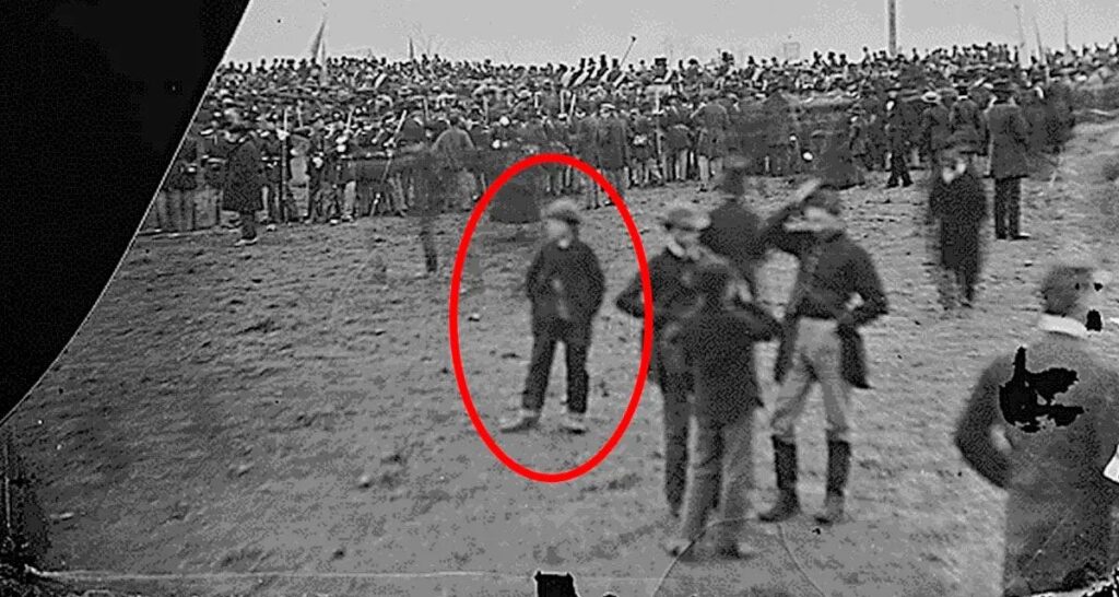 Fotografía histórica de la multitud en Gettysburg, con un círculo rojo resaltando a una figura infantil que se afirma es Andrew Basiago de niño, un viajero en el tiempo del Proyecto Pegasus.
