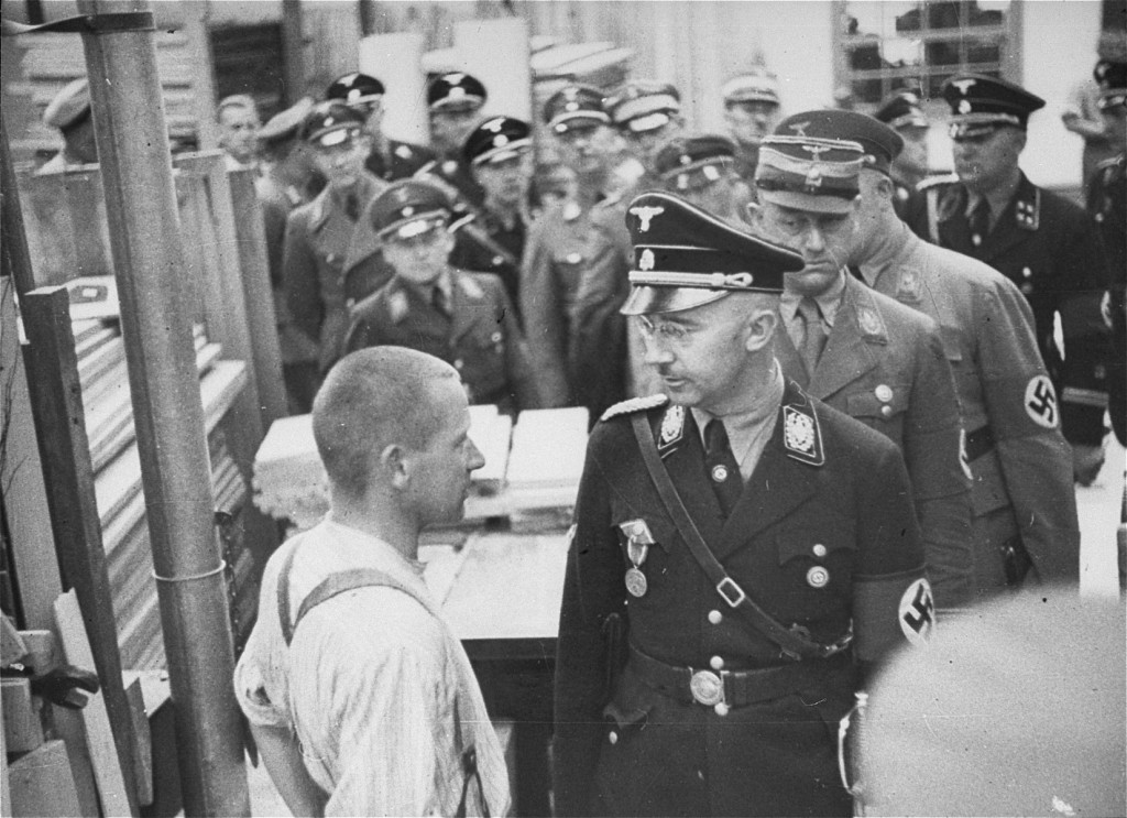 Ilustración conceptual de Heinrich Himmler con uniforme de las SS y gafas, en un despacho oscuro del Tercer Reich, rodeado de documentos de la Ahnenerbe y simbología esotérica nazi.