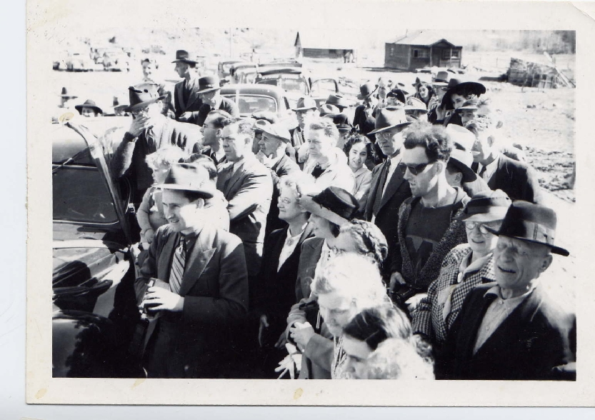 Multitud en la reapertura del South Fork Bridge con el famoso viajero del tiempo 1941 usando gafas de sol modernas y camiseta estampada.